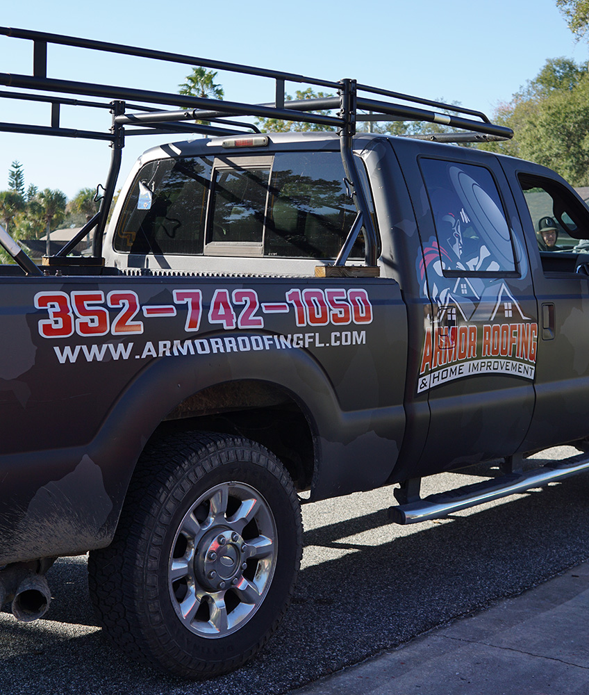 picture of the side of a pick up truck that is branded with Armor Roofing & Home improvement logo, phone numbers and website. This picture was taken while the truck was on location at a recent job in Central Florida.