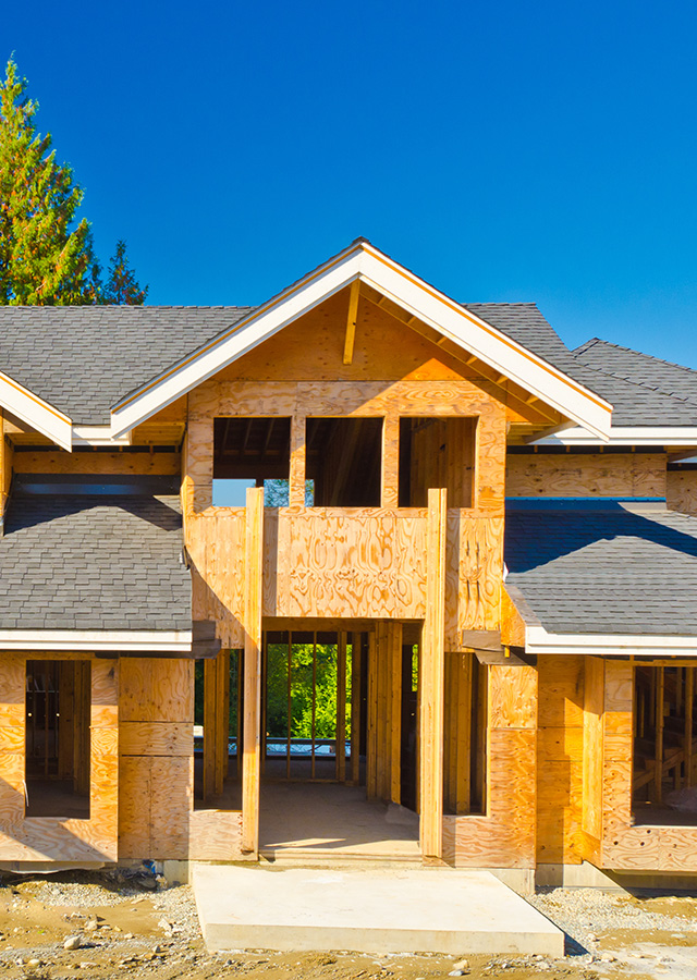 front view of the front door and roof of a new construction home that is in the framing phase of construction