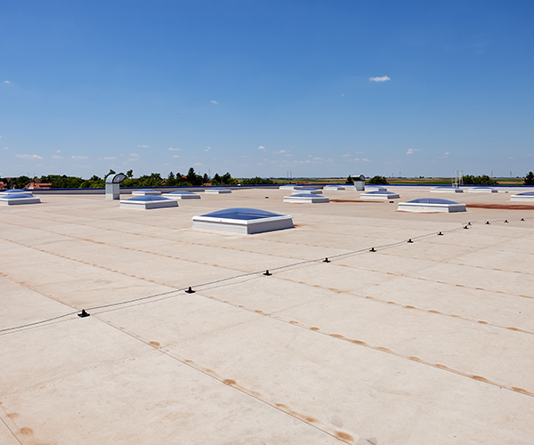 Image on the top of a commercial roof looking out to the vents that are on the roof.